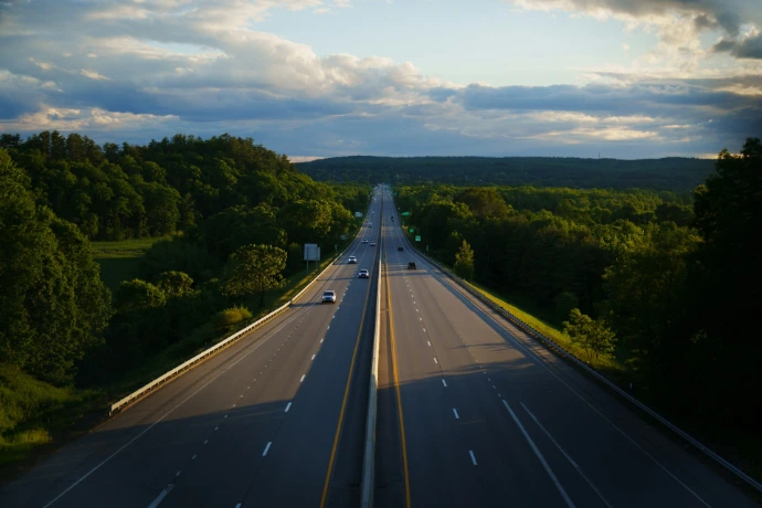 An aerial view of a highway in the middle of a forest
